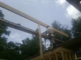 Carpenter setting a ridge beam over a new addition frame — Ice Dam Removal by Roofing Brothers in Cortlandt Manor