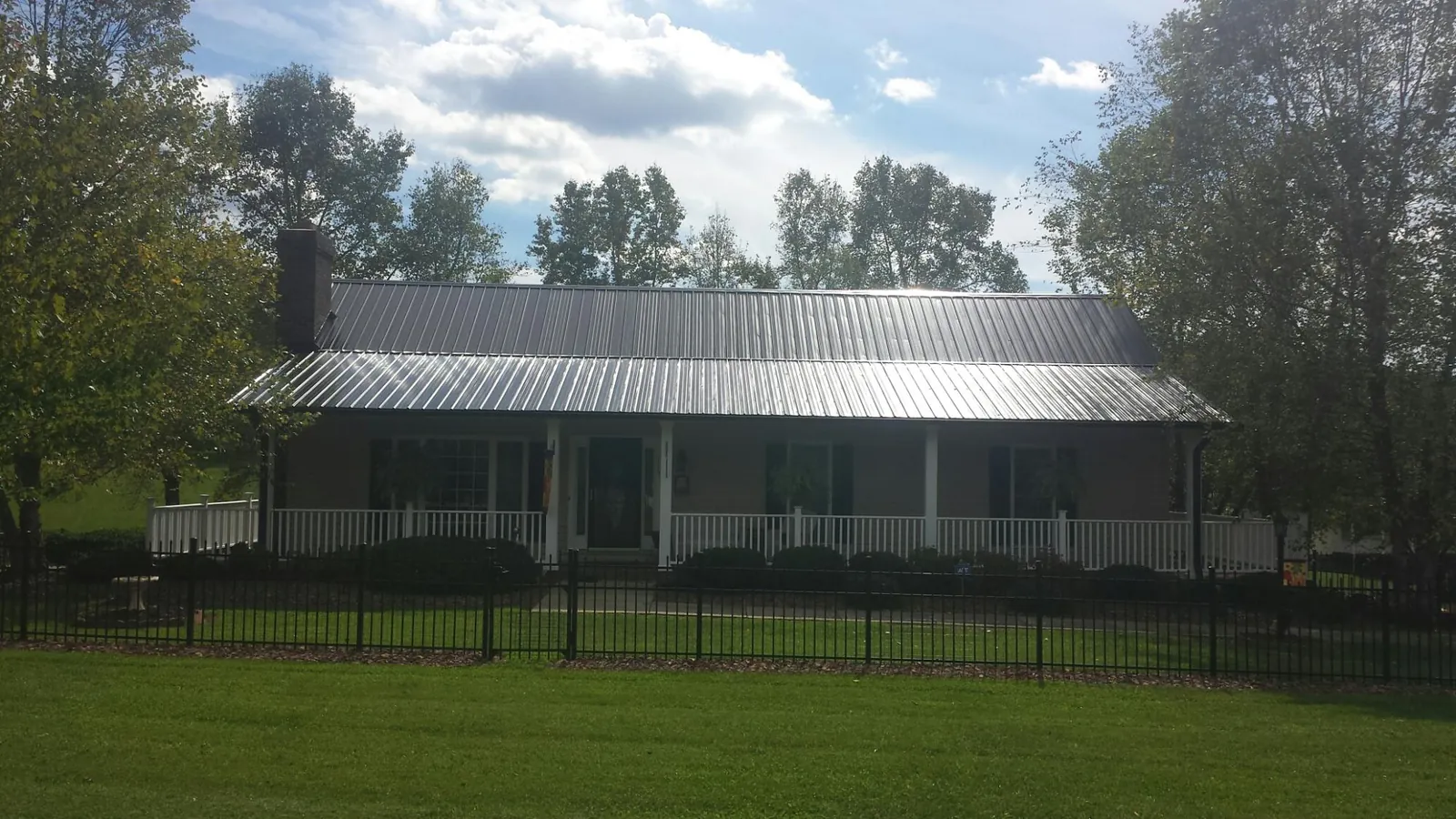 Gray metal roof on a brick ranch with a full width front porch — Gutter Guard Installation work by our crew in Cortlandt Manor