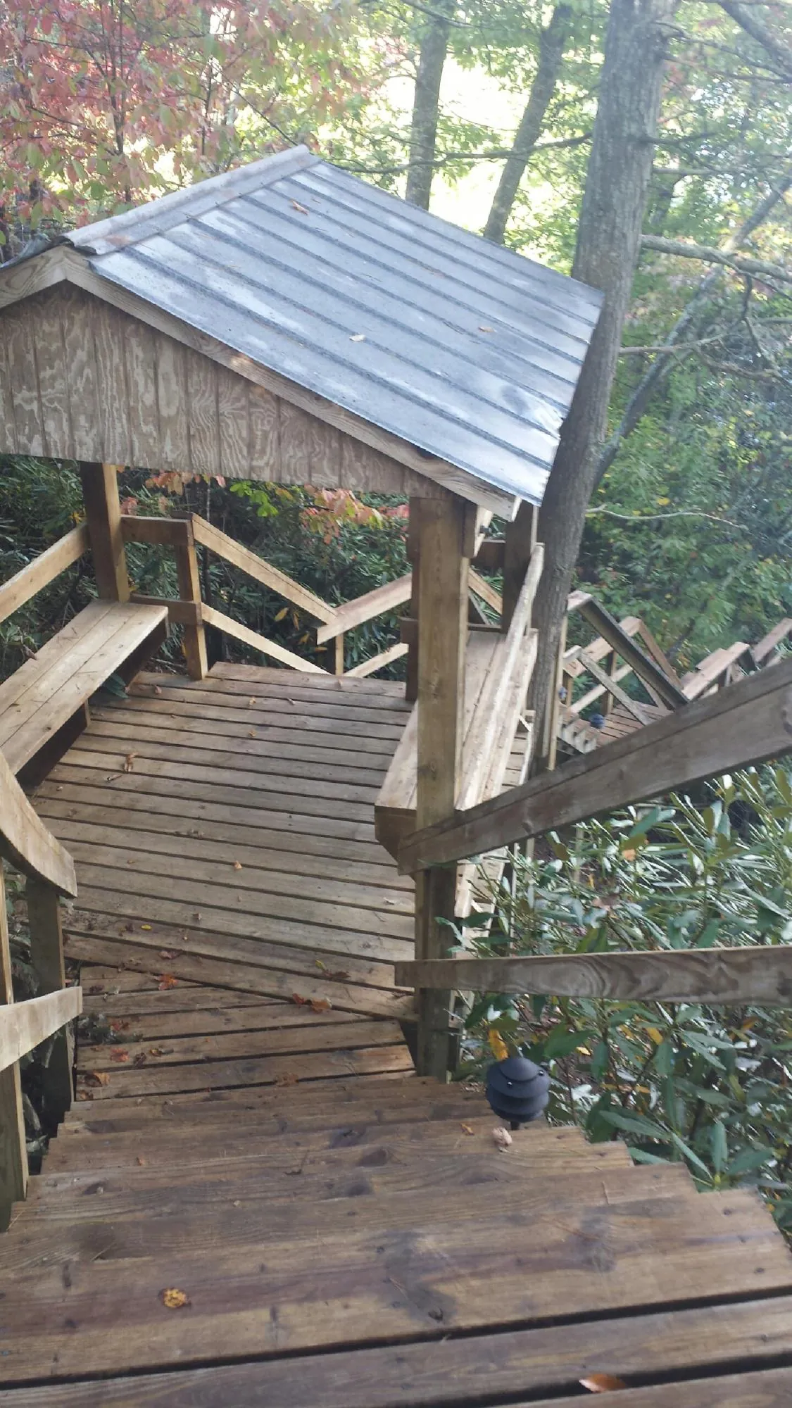 Metal roofed shelter over wooden steps on a wooded walkway — Skylight Repair & Installation work by our crew in Cortlandt Manor