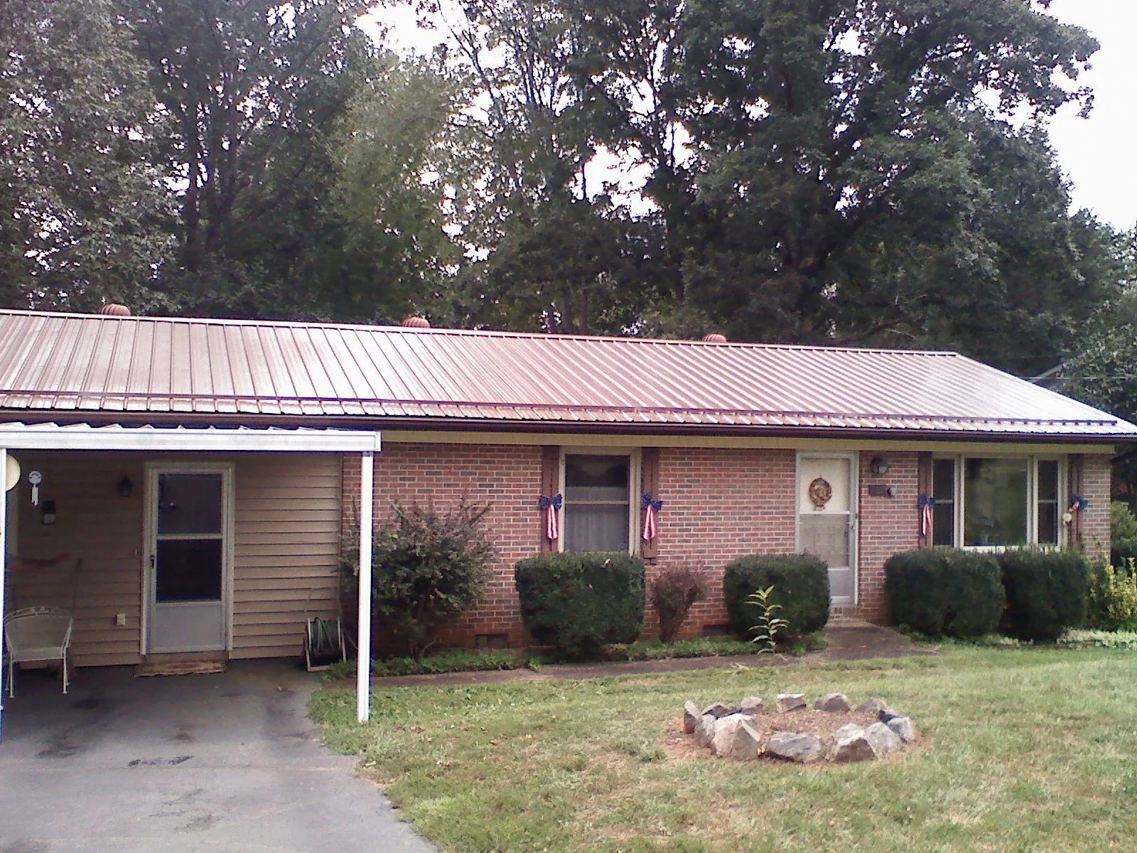 Bronze metal roof and carport on a brick ranch home — Roof Repair work by our crew in Cortlandt Manor